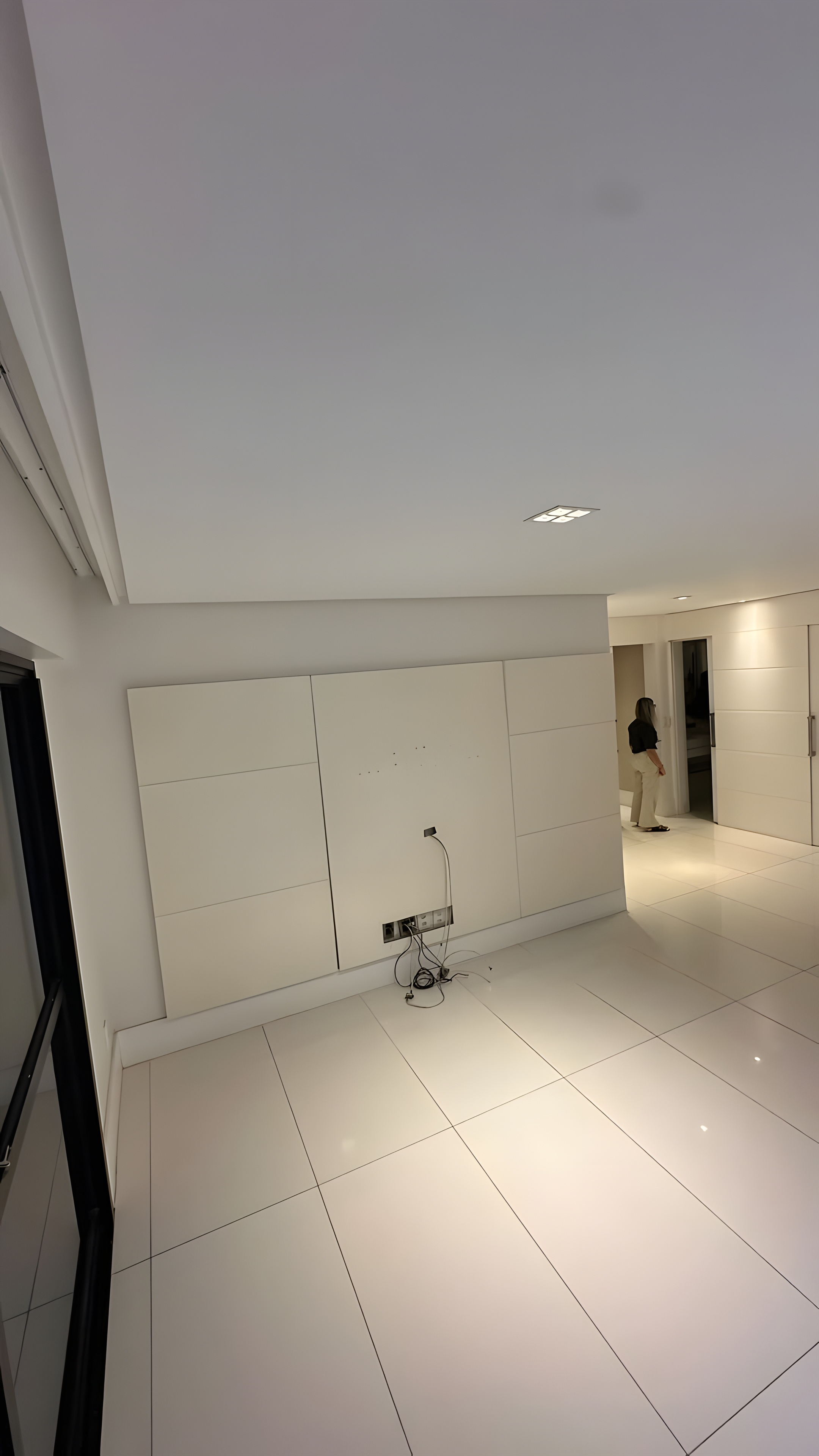 Parede com painéis brancos e piso porcelanato no imóvel existente