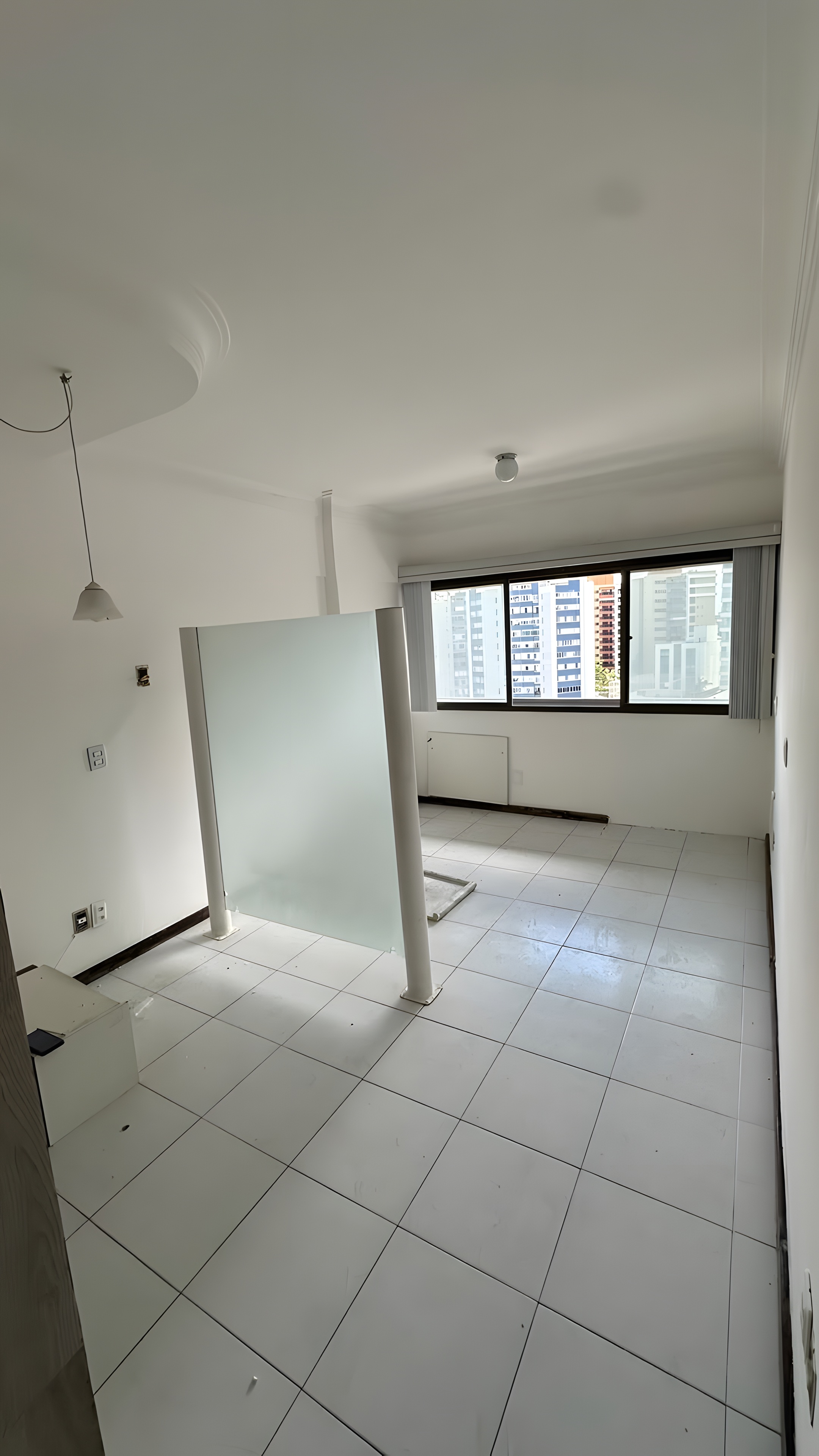 Sala existente com divisórias em vidro jateado e janela